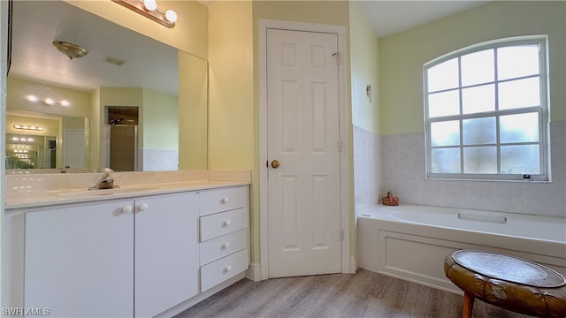 bathroom featuring shower with separate bathtub, hardwood / wood-style floors, and vanity