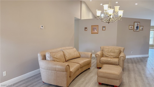 living room featuring a notable chandelier, light wood-type flooring, and high vaulted ceiling