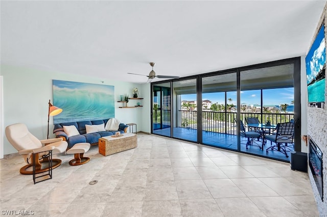 living room featuring a wall of windows and ceiling fan