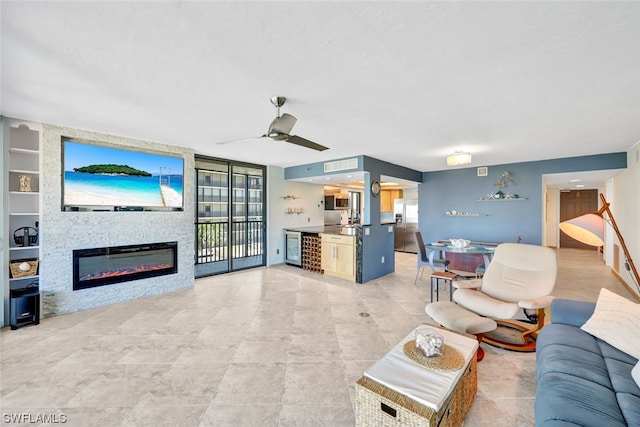 living room with ceiling fan, built in features, a fireplace, and beverage cooler