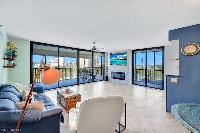 tiled living room featuring a fireplace, floor to ceiling windows, a healthy amount of sunlight, and ceiling fan