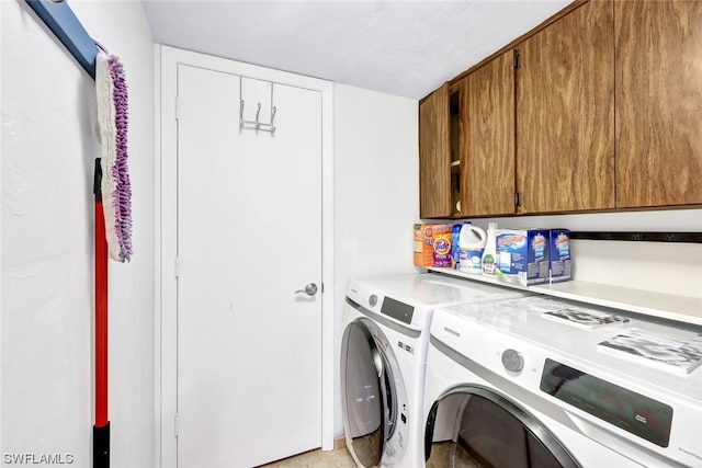 washroom featuring cabinets and washing machine and dryer