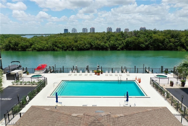 view of pool with a patio and a water view