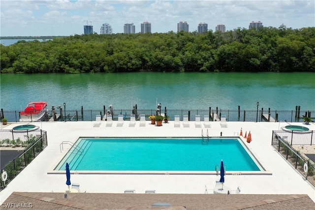 view of swimming pool featuring a patio area and a water view