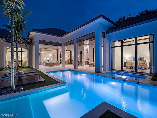 pool at night with a patio area