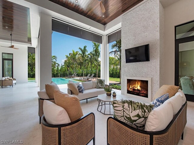 view of patio / terrace with an outdoor living space with a fireplace and ceiling fan