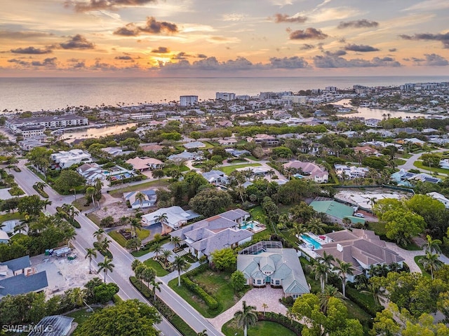 aerial view at dusk featuring a water view