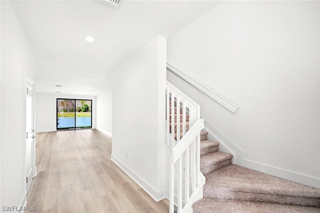 staircase with hardwood / wood-style floors