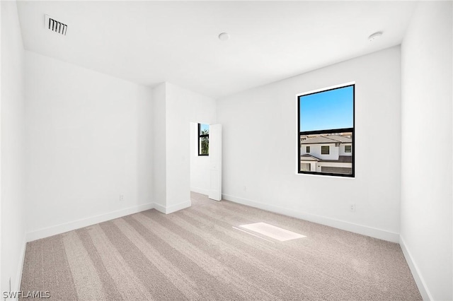 unfurnished room featuring light colored carpet