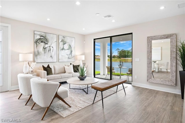 living room featuring hardwood / wood-style floors and a water view