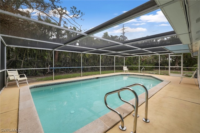 view of pool with glass enclosure and a patio