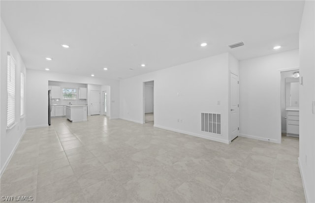 unfurnished living room with light tile flooring