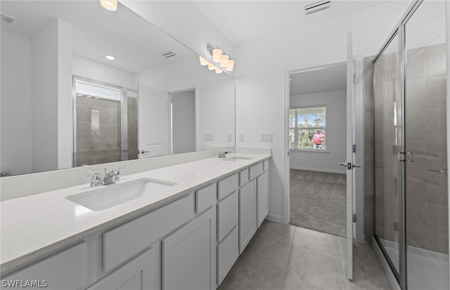 bathroom with tile flooring, dual sinks, large vanity, and a shower with shower door