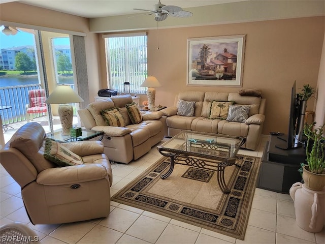 living room with light tile floors, ceiling fan, and a water view