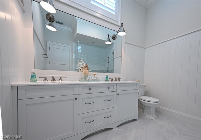 bathroom with vanity, crown molding, a shower with shower door, and toilet