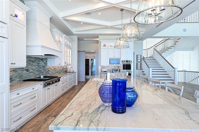 kitchen featuring hanging light fixtures, a barn door, and white cabinets