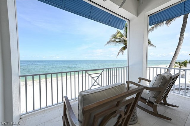 balcony featuring a water view and a beach view