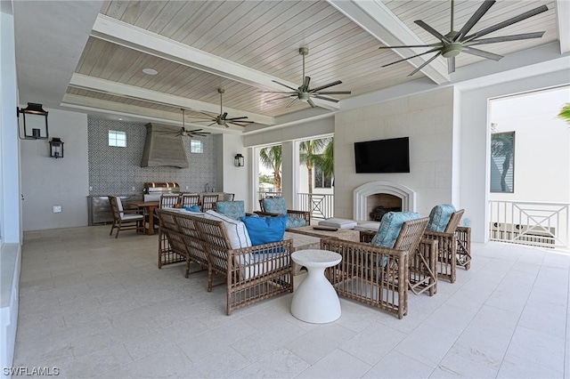 view of patio with ceiling fan and an outdoor living space with a fireplace