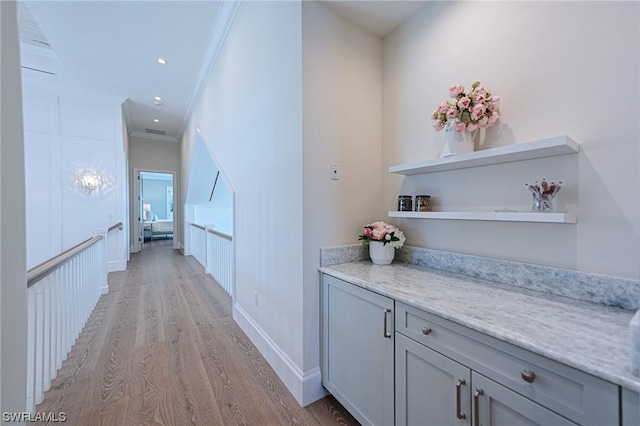 hall with crown molding and light hardwood / wood-style floors