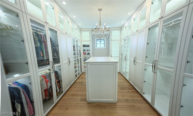 spacious closet featuring a notable chandelier and light hardwood / wood-style floors