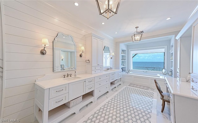 bathroom with a washtub, a water view, vanity, a notable chandelier, and ornamental molding