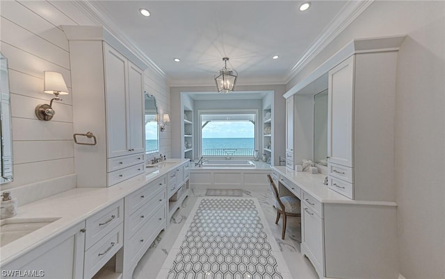 bathroom with vanity, a bathtub, and ornamental molding