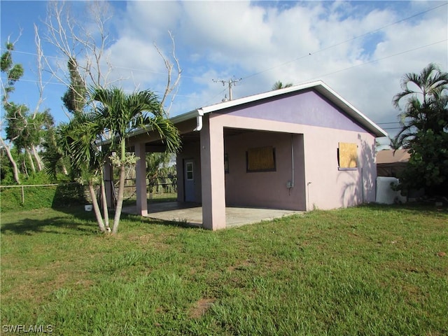 back of property featuring a patio area and a lawn