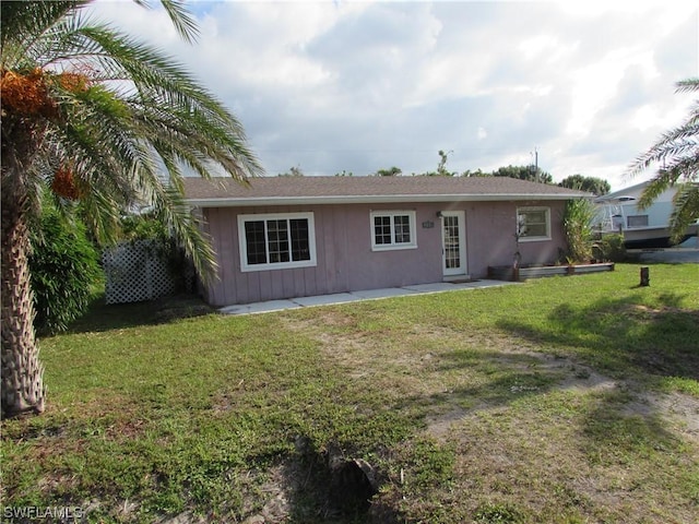 rear view of property featuring a yard