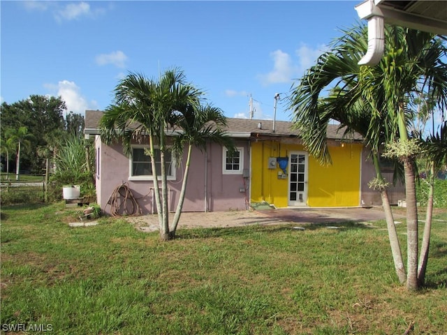 back of property featuring a yard and a patio area