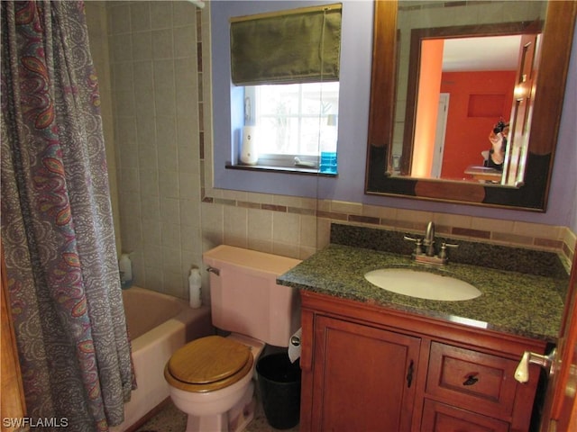 full bathroom with tile walls, vanity, toilet, and shower / tub combo with curtain