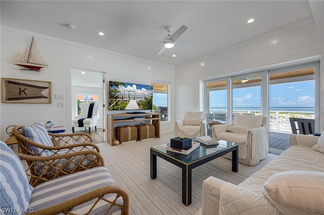 carpeted living room with plenty of natural light, ornamental molding, and ceiling fan