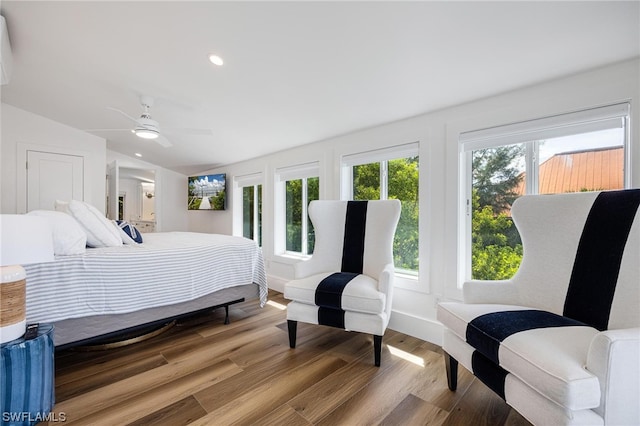 bedroom featuring a wall mounted AC, wood-type flooring, ceiling fan, and lofted ceiling