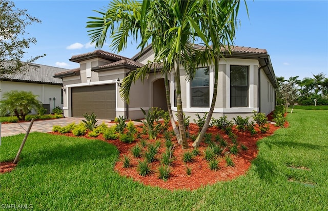 mediterranean / spanish-style house featuring a front lawn and a garage