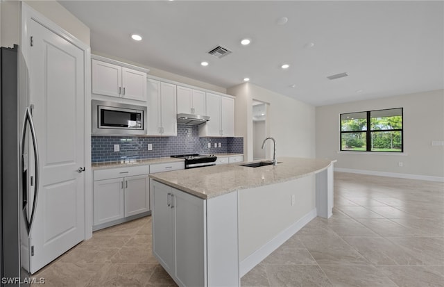 kitchen featuring stainless steel appliances, light tile floors, a center island with sink, white cabinetry, and sink