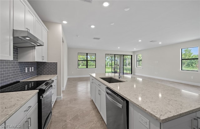 kitchen with an island with sink, sink, electric range, dishwasher, and white cabinetry