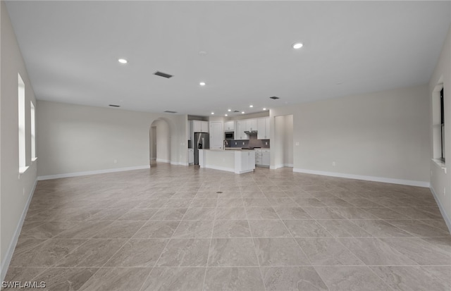 unfurnished living room featuring light tile floors