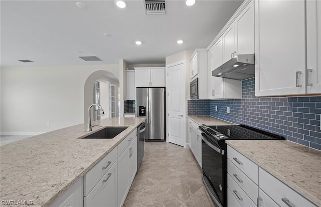 kitchen featuring stainless steel appliances, light tile floors, light stone countertops, white cabinetry, and sink