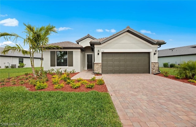 view of front facade with a front yard, central AC, and a garage