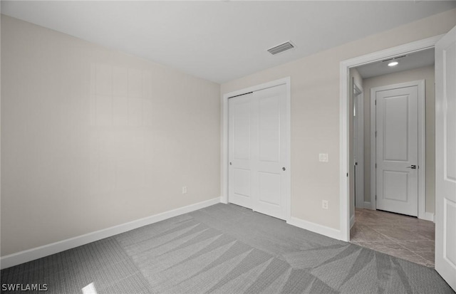 unfurnished bedroom with light carpet and a closet