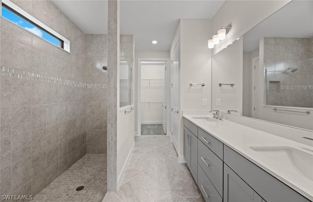 bathroom featuring a tile shower and vanity