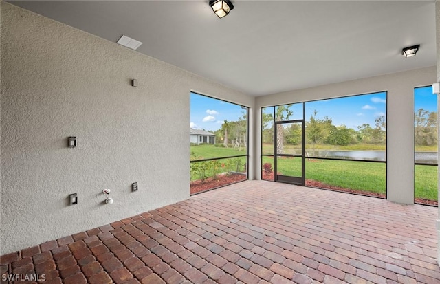 unfurnished sunroom with a water view