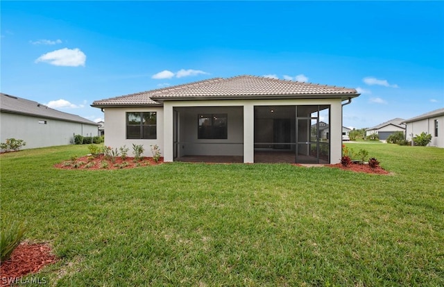 back of property with a sunroom and a lawn