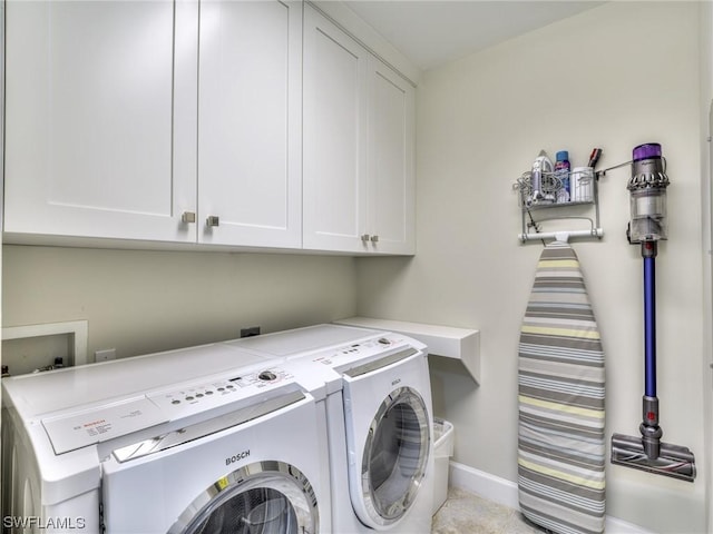 laundry room with cabinets and washing machine and clothes dryer