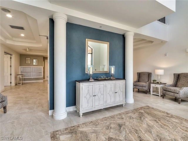 interior space featuring a tray ceiling and ornate columns