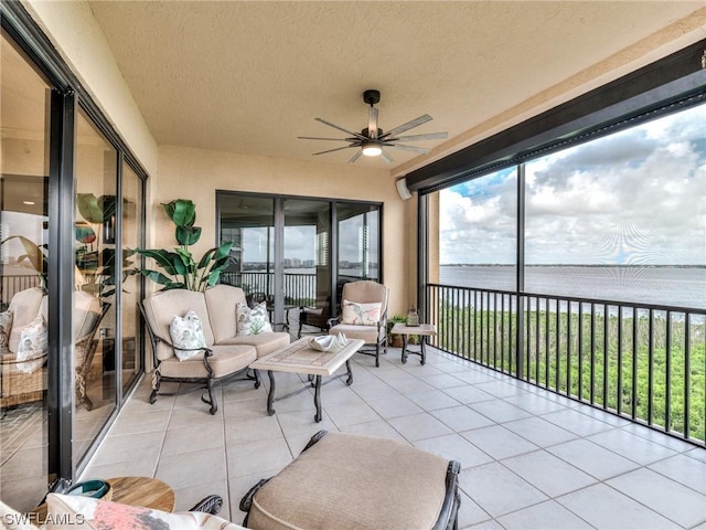 sunroom / solarium featuring a water view and ceiling fan