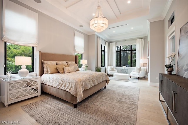 bedroom with ornamental molding, multiple windows, a chandelier, and light wood-type flooring