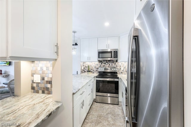 kitchen featuring light stone counters, stainless steel appliances, light tile flooring, tasteful backsplash, and white cabinetry