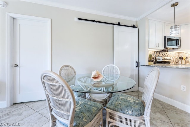 dining area with a barn door, ornamental molding, and light tile floors