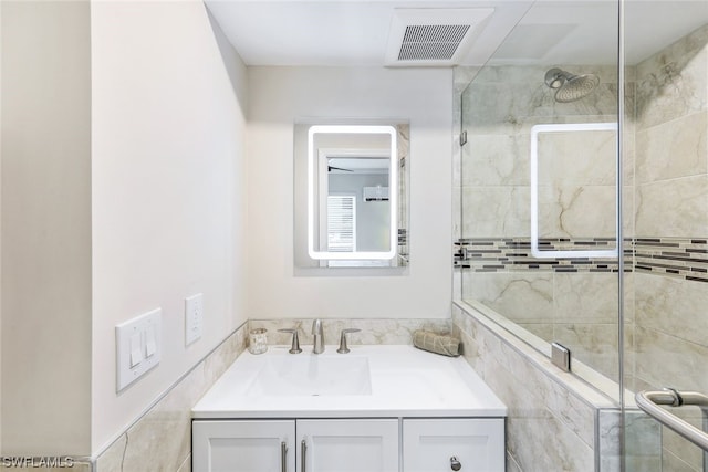 bathroom with vanity and a shower with shower door