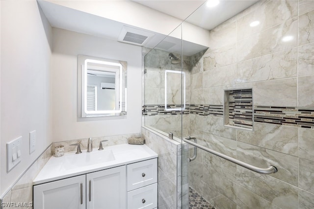 bathroom featuring vanity and a shower with shower door